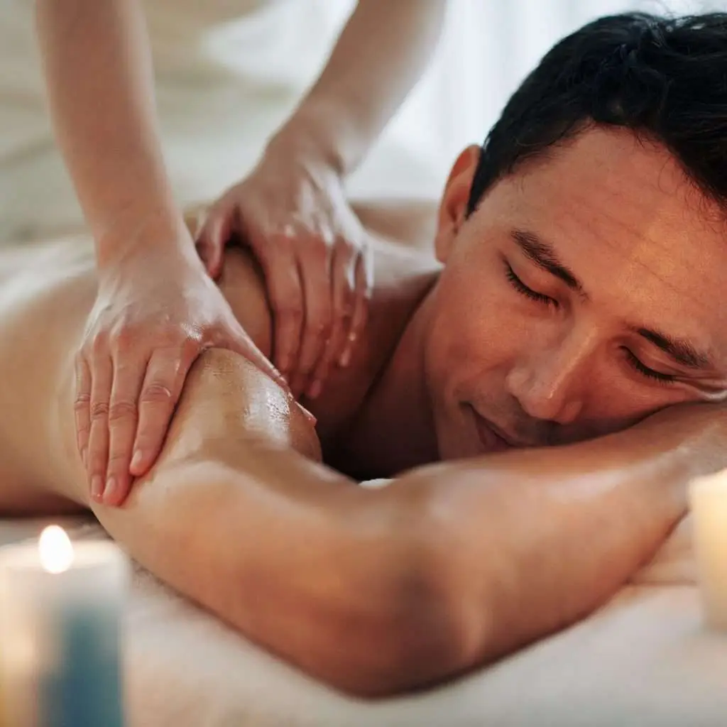 man enjoying a deep tissue spa massage on shoulder muscle knots at escape day spa